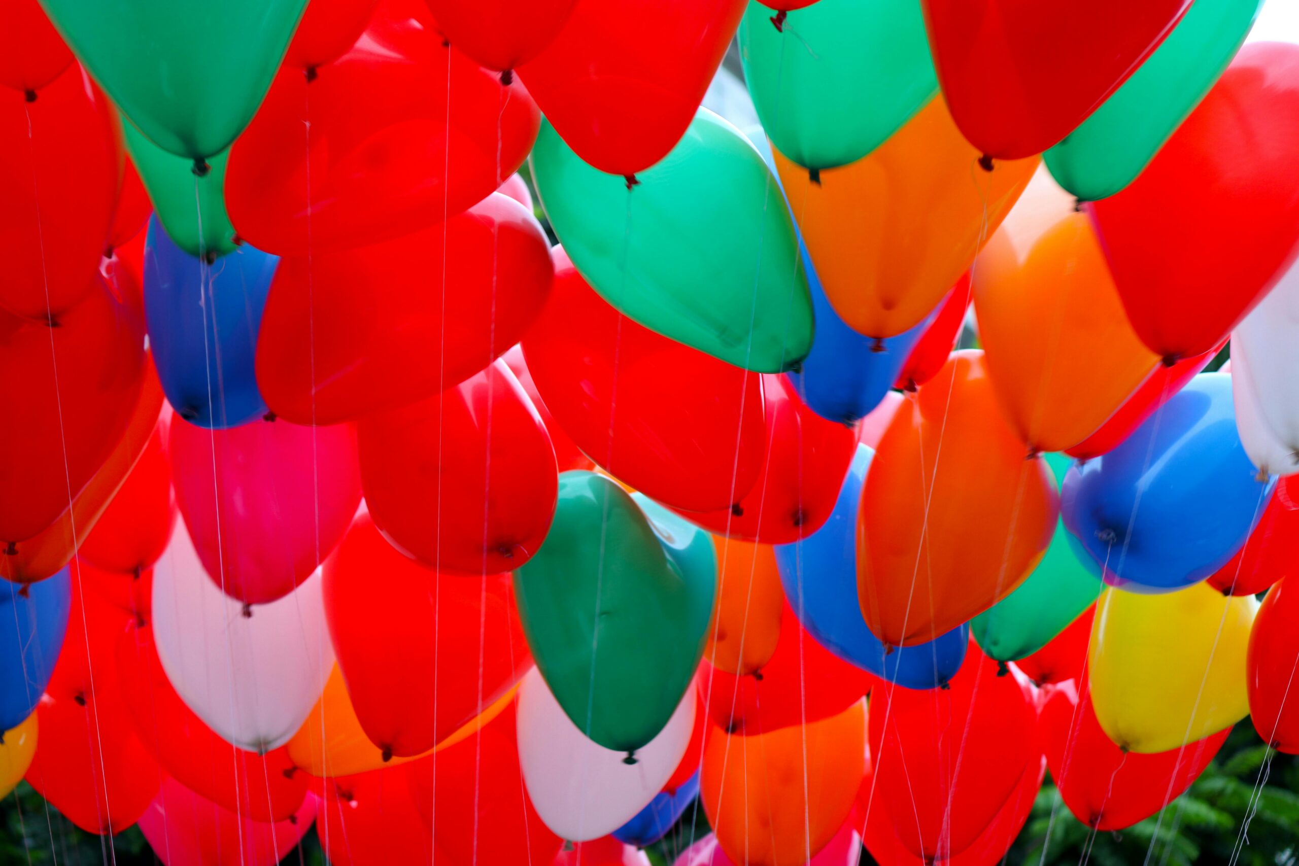 A stunning array of vibrant, colorful balloons floating closely together, creating a cheerful scene.